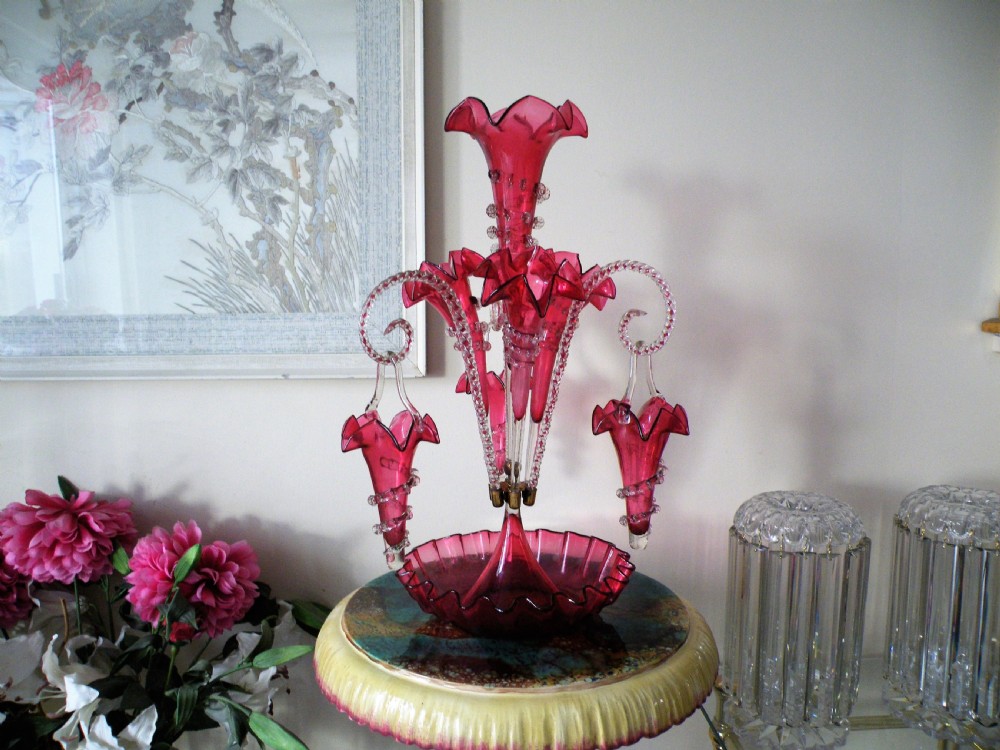 an extremely rare victorian cranberry glass epergne with baskets and rare cranberry twist canes