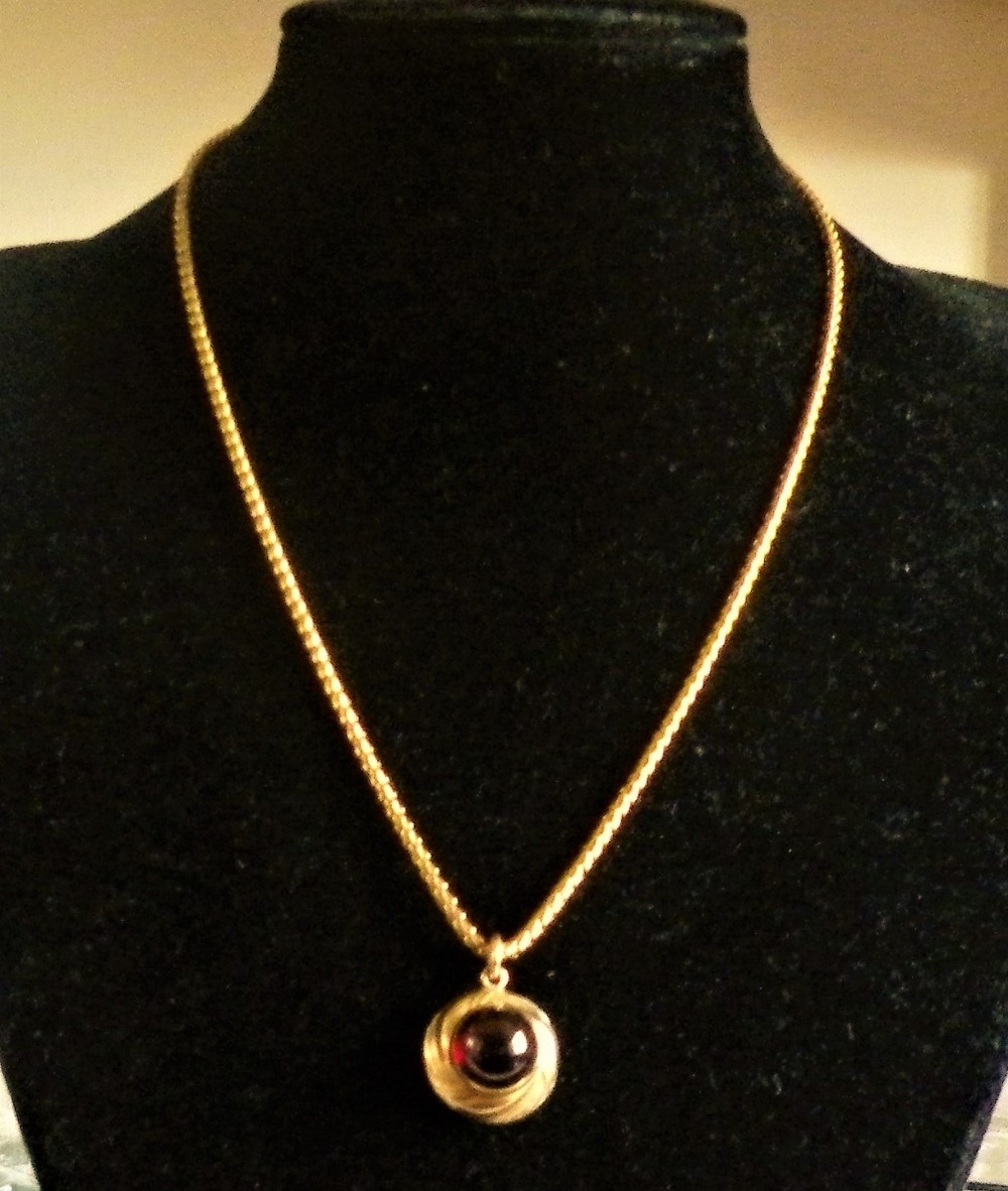 an early 19th century cabachon garnet pendant with locket back compartment