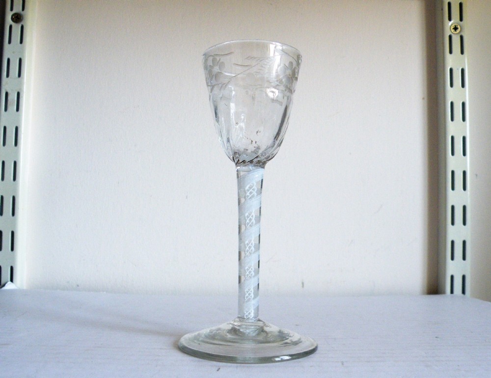 an 18th century opaque twist stem wine glass with engraved and half moulded bowl