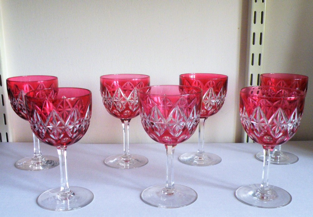 a lovely set of seven victorian cranberry cut to clear wine glasses