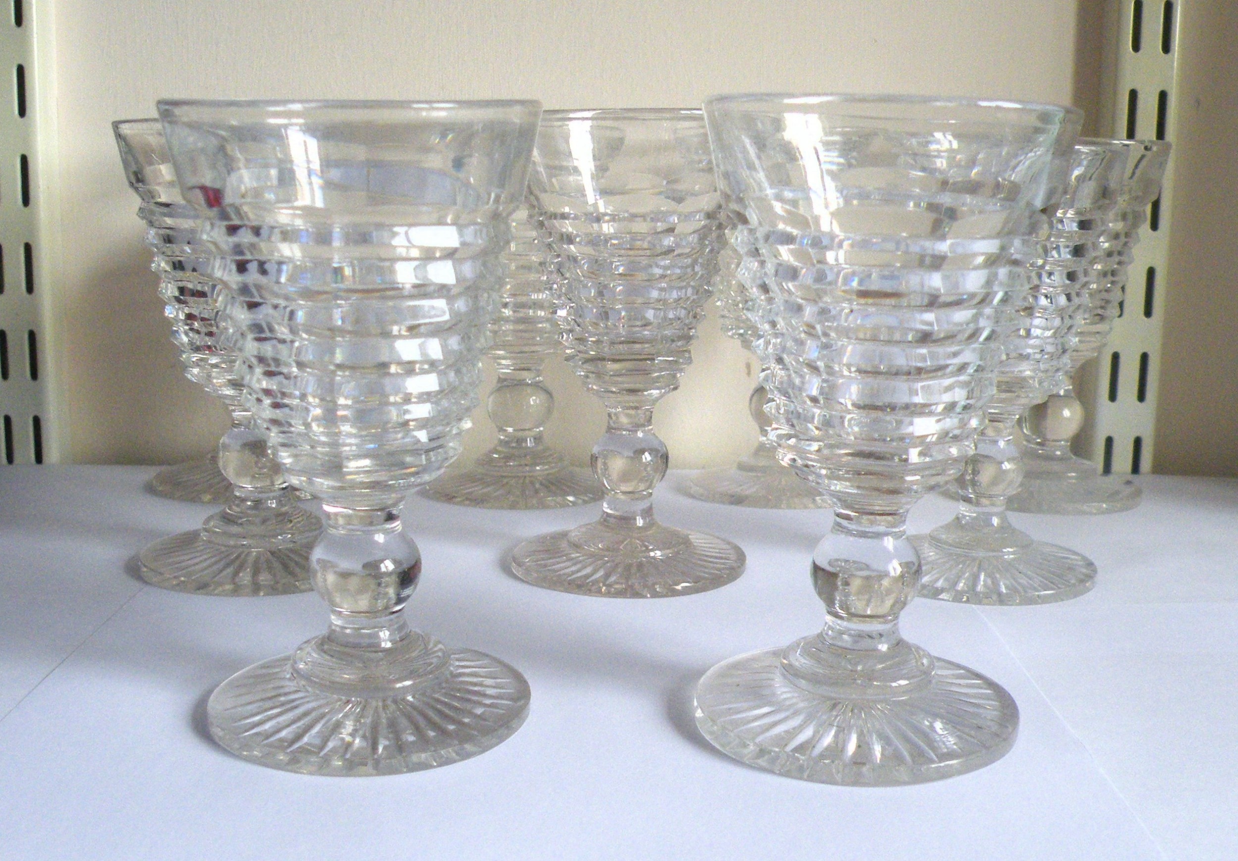 a fine quality hand made set of nine regency cut glass port glasses